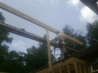 Carpenter setting a ridge beam over a new addition frame — Ice Dam Removal by Roofing Brothers in Croydon