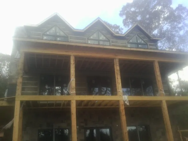 Dormers and porch framing on a large log home under construction — Roof Coating work by our crew in Croydon